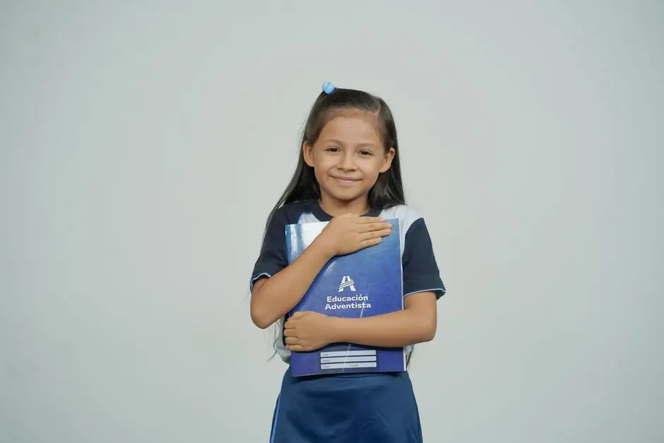 Anak tersenyum sambil memegang buku pelajaran di teras rumah Mungkid